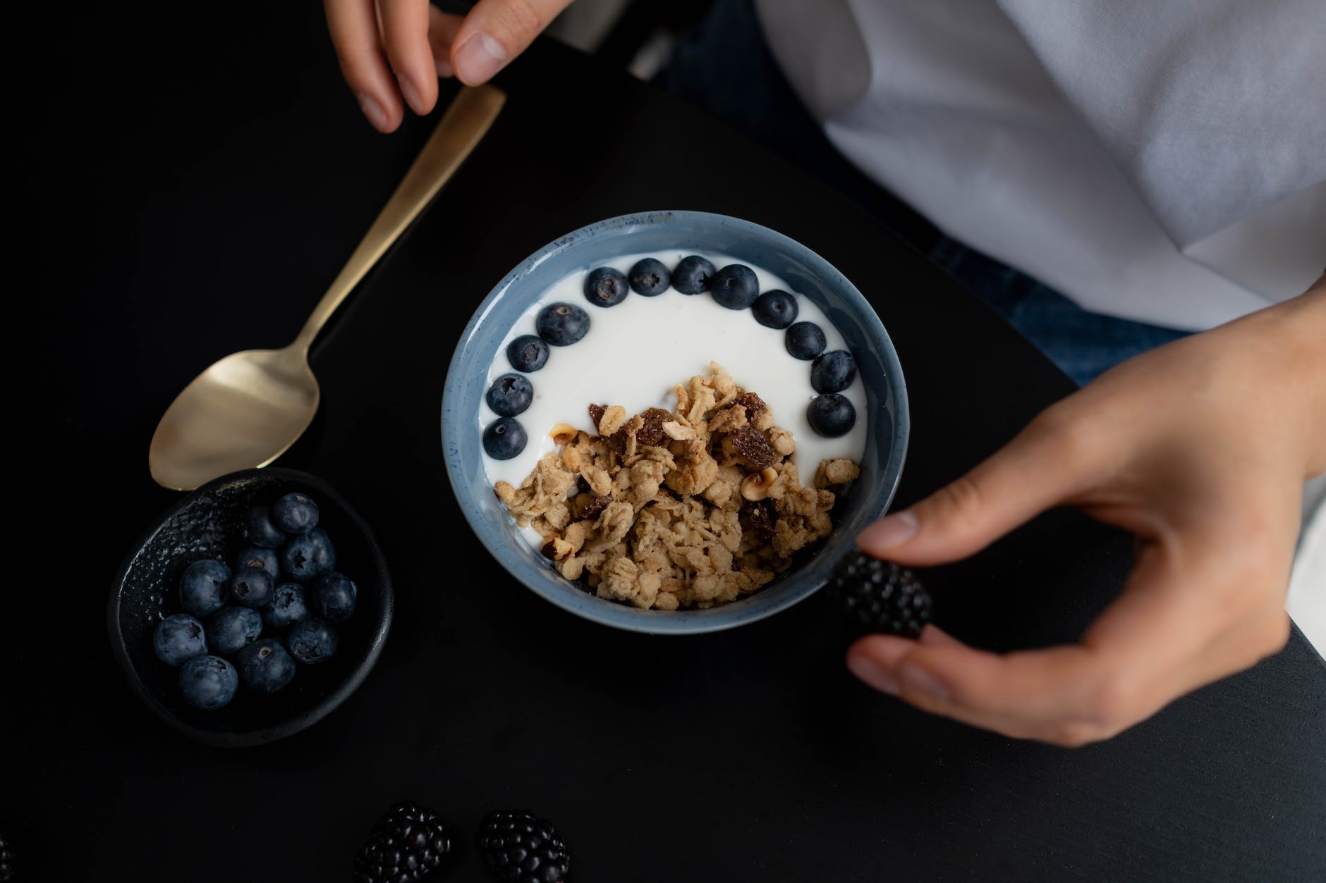 bowl with granola milk and blueberries on black table UK Dairy-Free Delights:  Our Top Picks